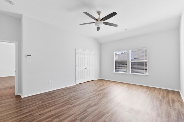 spare room featuring ceiling fan, wood-type flooring, and vaulted ceiling