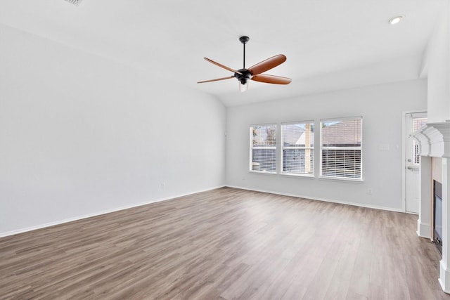 unfurnished living room featuring ceiling fan, vaulted ceiling, and light hardwood / wood-style flooring