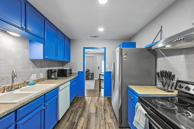 kitchen featuring blue cabinets, sink, tasteful backsplash, appliances with stainless steel finishes, and dark hardwood / wood-style floors