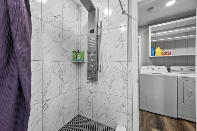 bathroom featuring hardwood / wood-style flooring, independent washer and dryer, and tiled shower