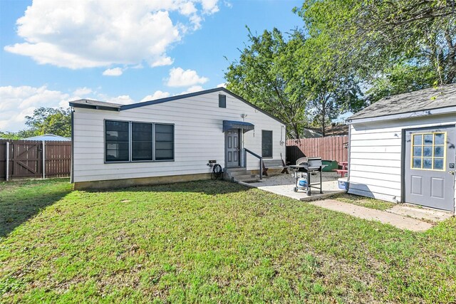 rear view of property featuring a yard and a patio