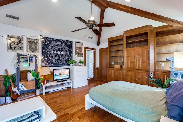 bedroom featuring hardwood / wood-style flooring and vaulted ceiling with beams