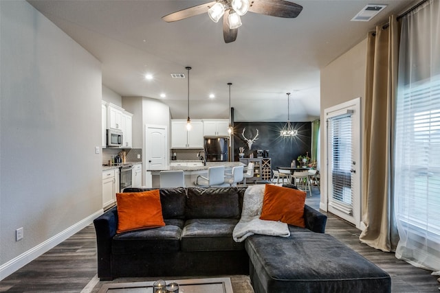 living room featuring dark hardwood / wood-style floors, ceiling fan, and sink