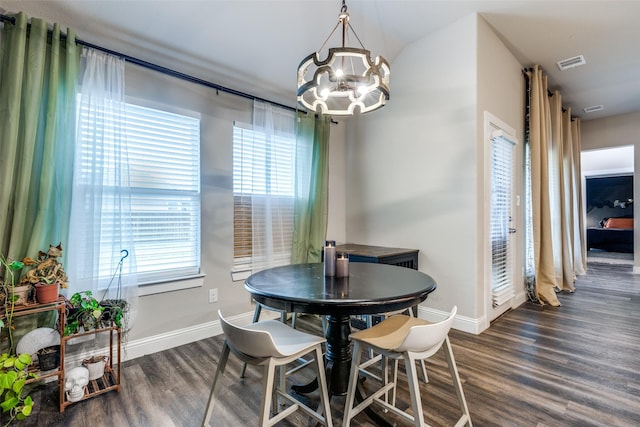 dining room featuring dark hardwood / wood-style flooring and an inviting chandelier