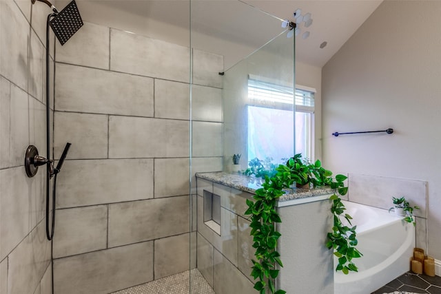 bathroom with tile patterned floors, independent shower and bath, and vaulted ceiling