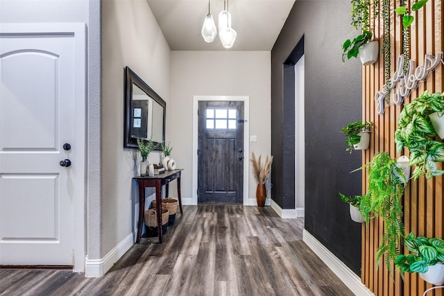 foyer featuring dark wood-type flooring and a notable chandelier