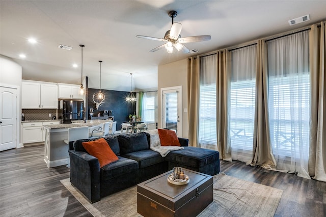 living room featuring ceiling fan, sink, and dark wood-type flooring