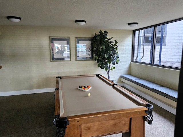 rec room with carpet, a textured ceiling, brick wall, and billiards