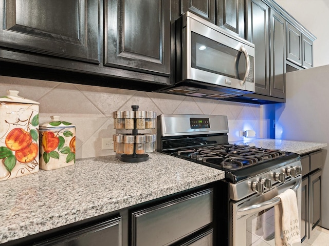 kitchen with light stone counters, stainless steel appliances, and tasteful backsplash