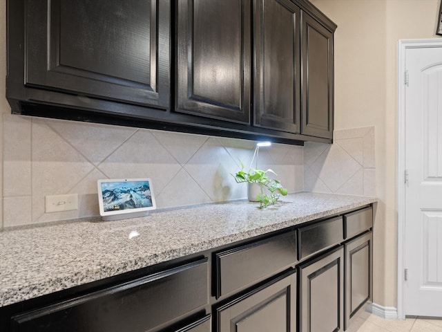 kitchen with light stone countertops, backsplash, and light tile patterned floors