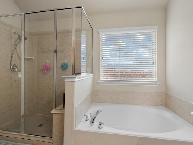 bathroom featuring shower with separate bathtub