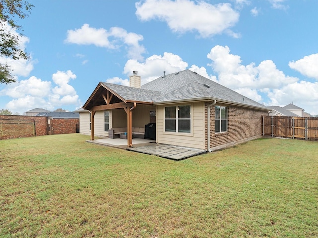 rear view of house with a lawn and a patio