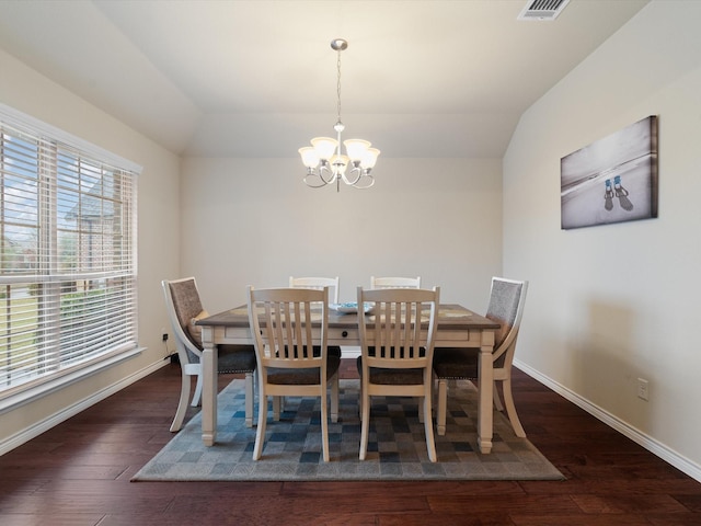 dining area featuring dark hardwood / wood-style flooring, a chandelier, and lofted ceiling