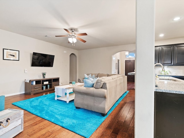 living room featuring ceiling fan, dark hardwood / wood-style flooring, and sink