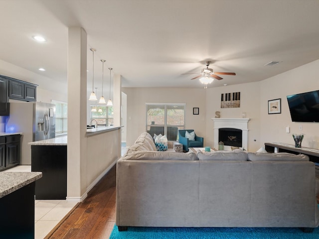 living room with dark hardwood / wood-style floors and ceiling fan