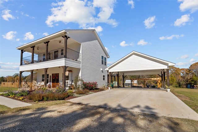 view of home's exterior with covered porch, a carport, a balcony, and ceiling fan