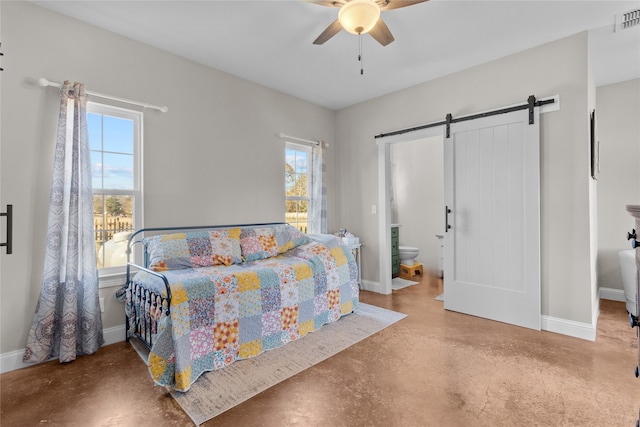 bedroom featuring concrete flooring, a barn door, ceiling fan, and ensuite bathroom