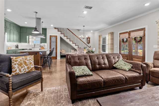 living room with crown molding, french doors, and a chandelier