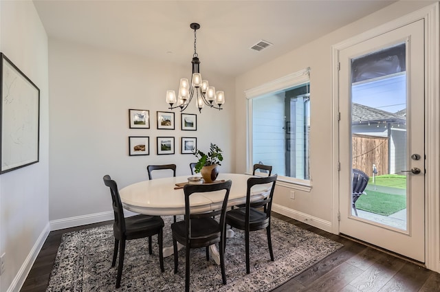 dining area featuring dark hardwood / wood-style floors and an inviting chandelier