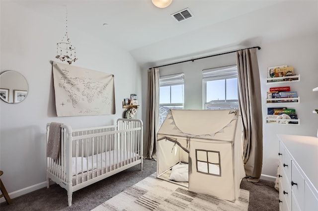 carpeted bedroom featuring a nursery area and lofted ceiling