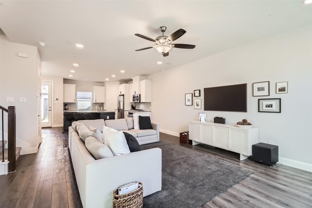 living room with ceiling fan, dark hardwood / wood-style flooring, and sink