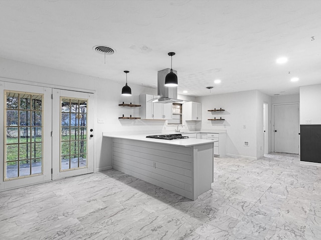 kitchen featuring white cabinets, black gas stovetop, sink, decorative light fixtures, and kitchen peninsula