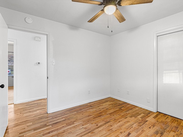 empty room with ceiling fan and light hardwood / wood-style flooring