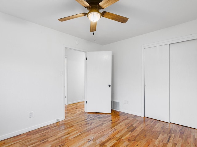 unfurnished bedroom with a closet, light hardwood / wood-style flooring, and ceiling fan