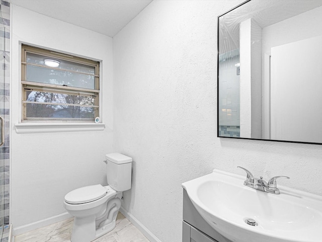 bathroom with vanity, a shower with shower door, and toilet