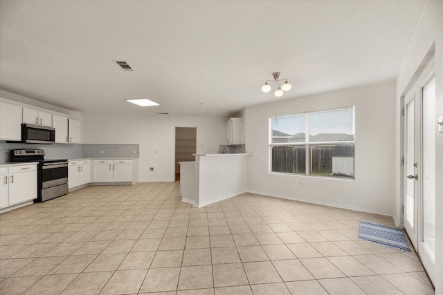 kitchen featuring white cabinets, light tile patterned floors, stainless steel appliances, and tasteful backsplash