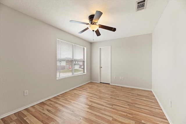 unfurnished room featuring a textured ceiling, light wood-type flooring, and ceiling fan