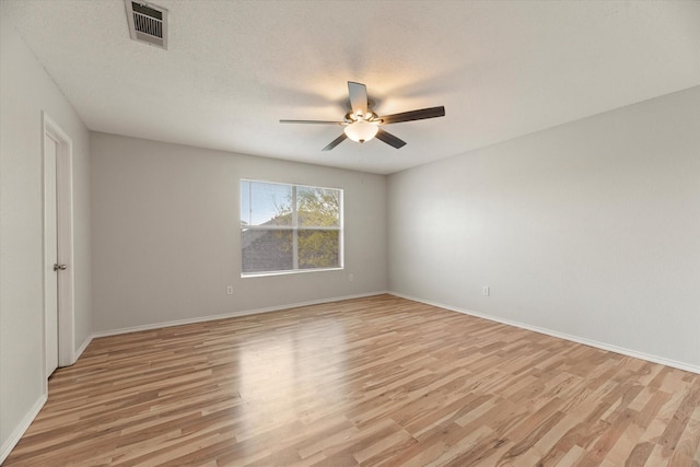 empty room with light hardwood / wood-style flooring and a textured ceiling