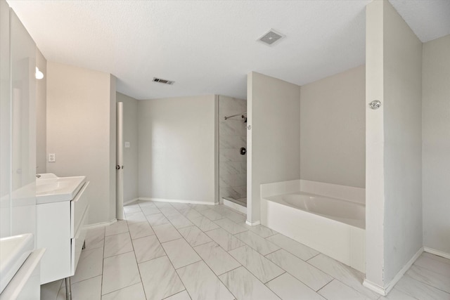 bathroom with vanity, separate shower and tub, and a textured ceiling