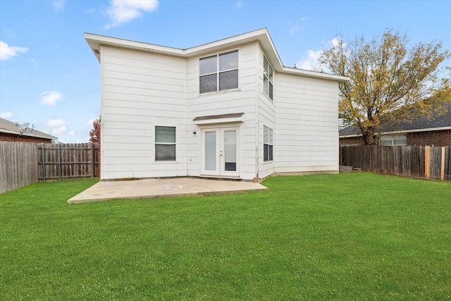 rear view of property featuring a yard and a patio area