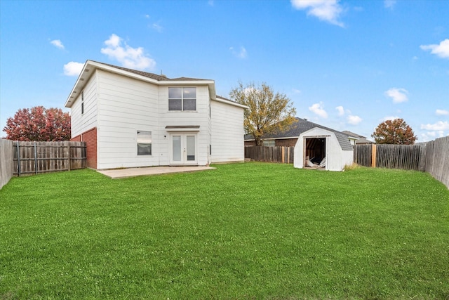 rear view of house featuring a storage unit, a yard, and a patio