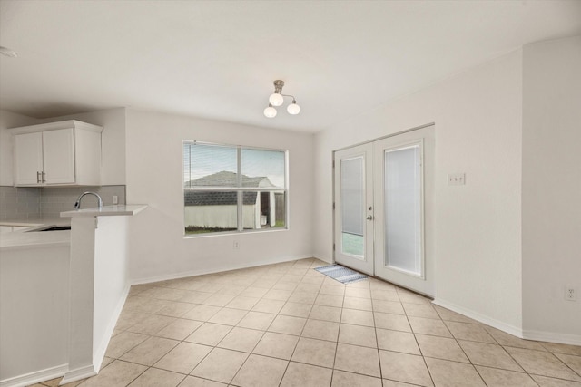 interior space featuring light tile patterned floors, sink, and french doors