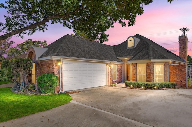 view of front of house with a garage and a yard