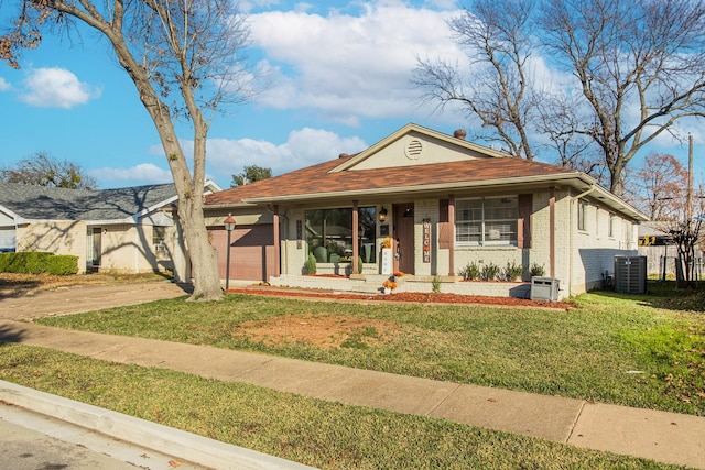 view of front facade featuring a porch, a garage, a front yard, and cooling unit