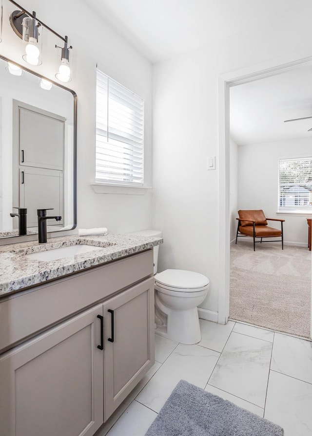 bathroom featuring ceiling fan, vanity, and toilet