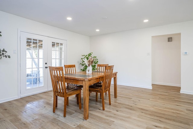 dining room featuring french doors and light wood-type flooring