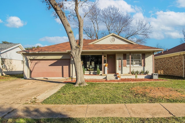 single story home with covered porch, a garage, and a front yard