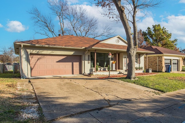 single story home featuring covered porch, a garage, central AC unit, and a front yard