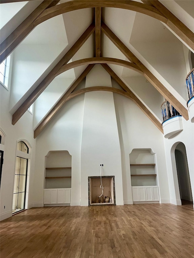 1133 Bourland Rd, Keller, TX 76248 - unfurnished living room featuring high vaulted ceiling, built in features, wood finished floors, baseboards, and beamed ceiling