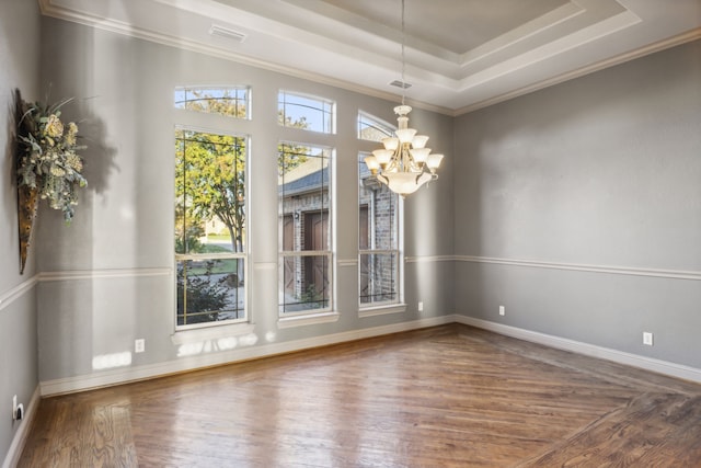 interior space with an inviting chandelier, wood-type flooring, and a raised ceiling