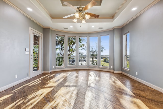 unfurnished room featuring ceiling fan, ornamental molding, wood-type flooring, and a raised ceiling