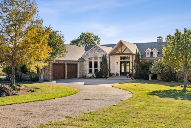 view of front of house with french doors, a garage, and a front lawn