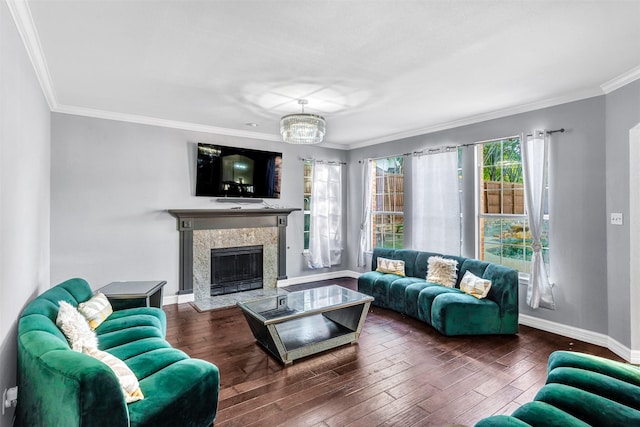 living room featuring dark hardwood / wood-style flooring, crown molding, a high end fireplace, and an inviting chandelier