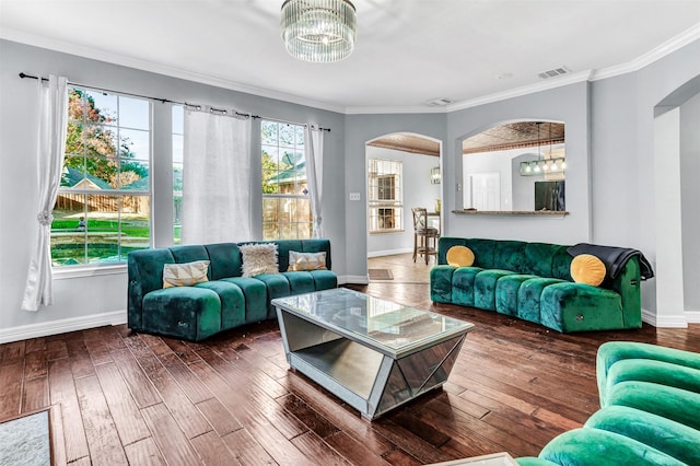 living room featuring a notable chandelier, crown molding, and dark wood-type flooring