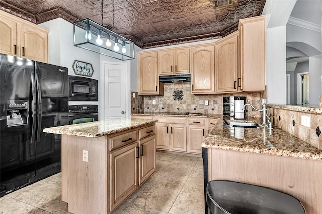 kitchen with light brown cabinets, black appliances, sink, a kitchen island, and light stone counters