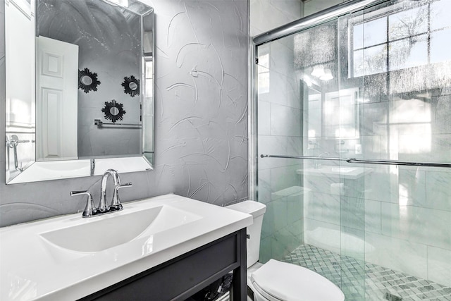 bathroom with an enclosed shower, vanity, and toilet